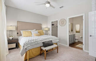 A bedroom with a bed, nightstands, and a ceiling fan.