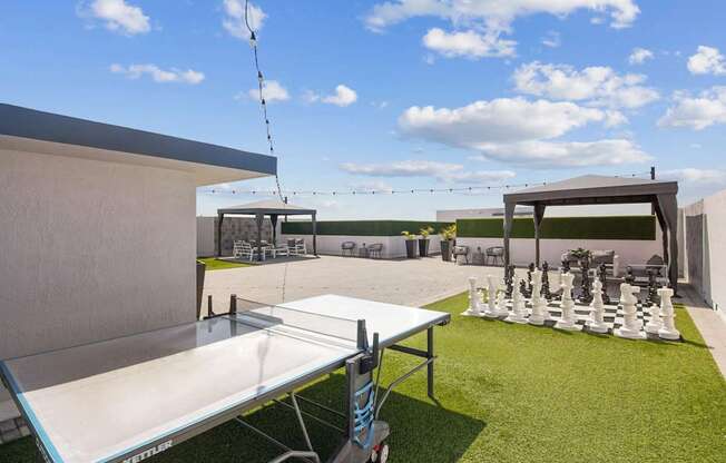 A white table tennis table is set up on a grassy area.