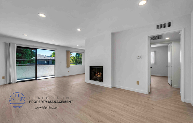 a large living room with hardwood floors and a fireplace