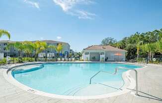 Pool with clubhouse in the background at Trillium luxury apartments in Melbourne fl