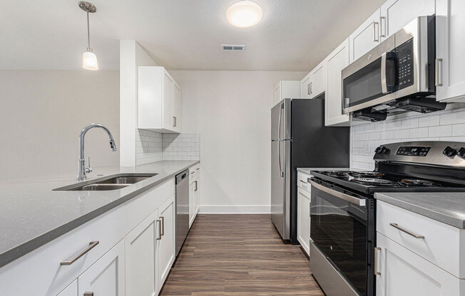 a kitchen with stainless steel appliances and white cabinets  at Signature Pointe Apartment Homes, Athens, Alabama