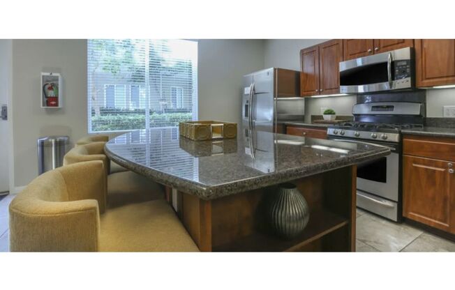 a kitchen with a counter top and a stove top oven  at Tesoro Senior Apartments, California, 91326