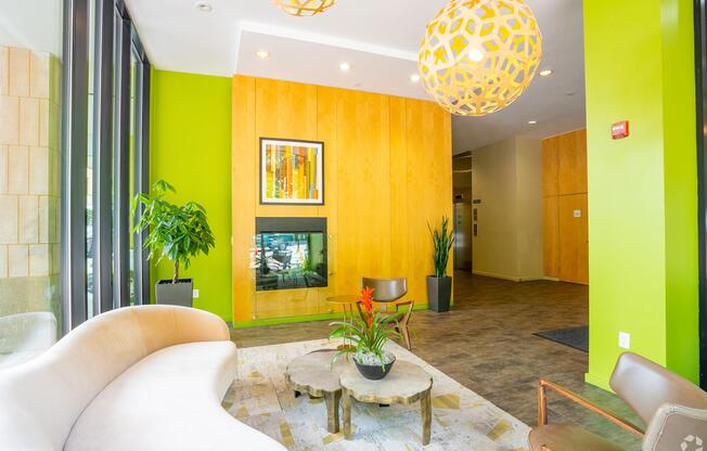 A white sofa sits in a room with a yellow wall and a painting hanging on it. at 603 Concord Apartments, Massachusetts