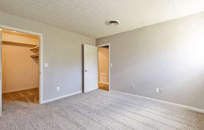 an empty living room with a closet and a door to a bedroom