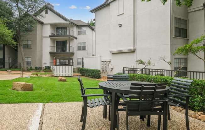 Al fresco dining table with apartment buildings in the back at Jefferson Place apartments in Irving, TX