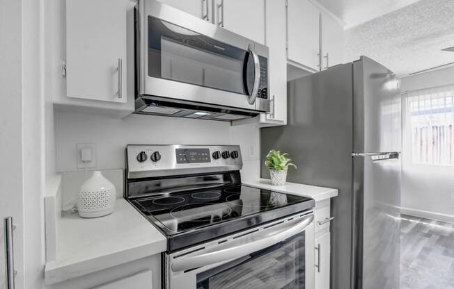 a kitchen with white cabinetry and stainless steel appliances