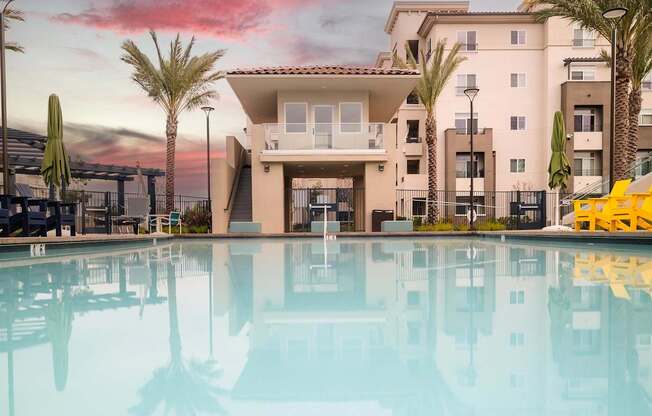 A large building with a pool in front of it.