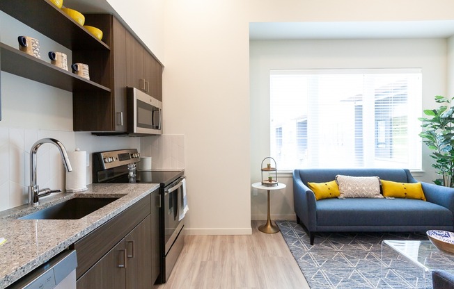 Open living area and kitchen with stainless steel appliances and modern fixtures
