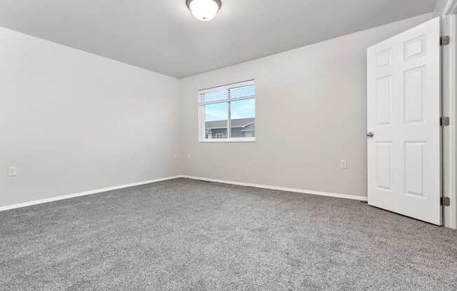 A room with a carpeted floor and a window.