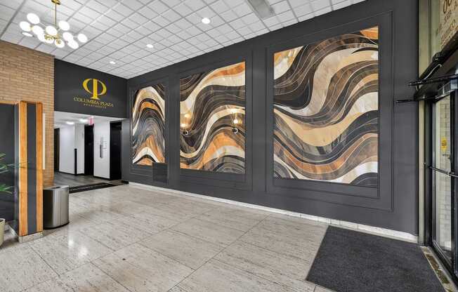 A hallway with a marble wallpaper design and a black and gold logo on the wall.