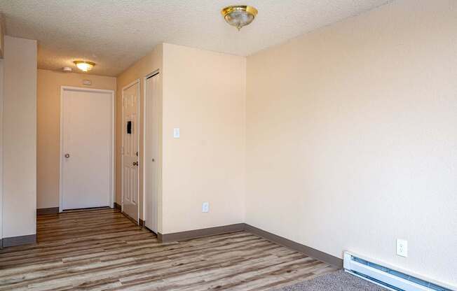 A room with a white door and a brown carpet.