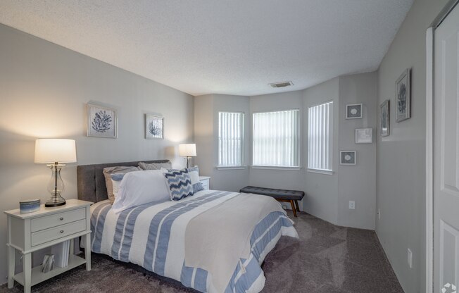 the master bedroom has a large bed and windows