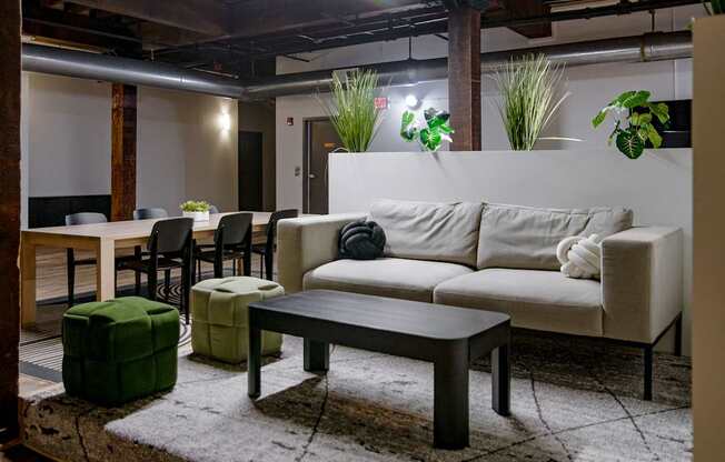 A living room with a white couch and a green ottoman.