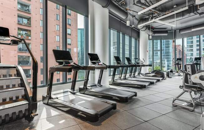 a row of treadmills in a fitness room with a view of the city  at Cassidy on Canal, Chicago, Illinois