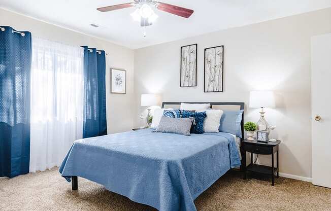 a bedroom with a bed and a ceiling fan