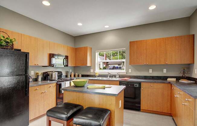 A kitchen with wooden cabinets and black appliances.