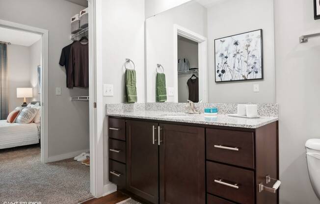 a bathroom with dark cabinets and a mirror and a toilet