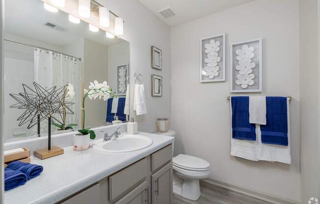 A bathroom with a white sink and a toilet.