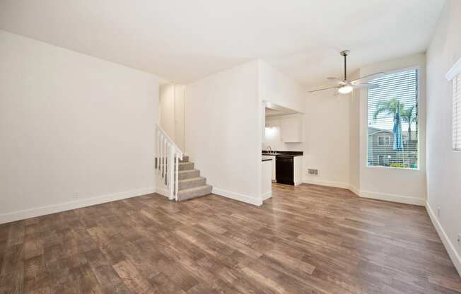 the living room and dining room of an empty home with wood flooring