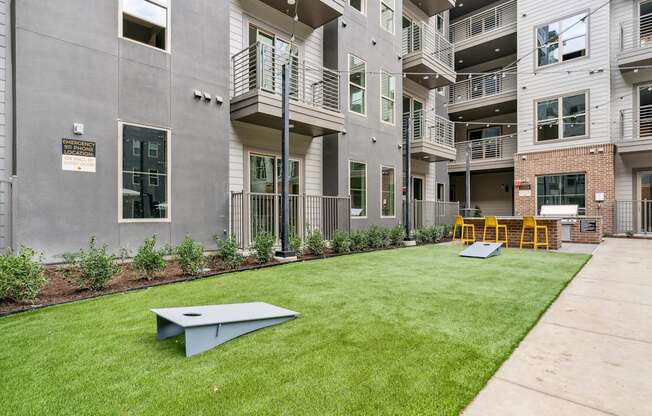 a yard with a ping pong table in front of an apartment building