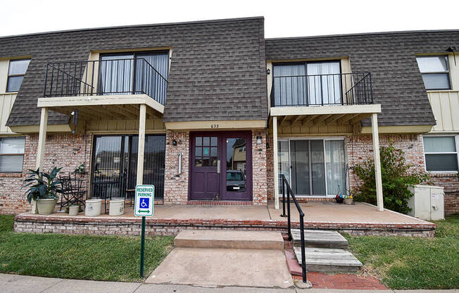 the front of a brick house with a purple door