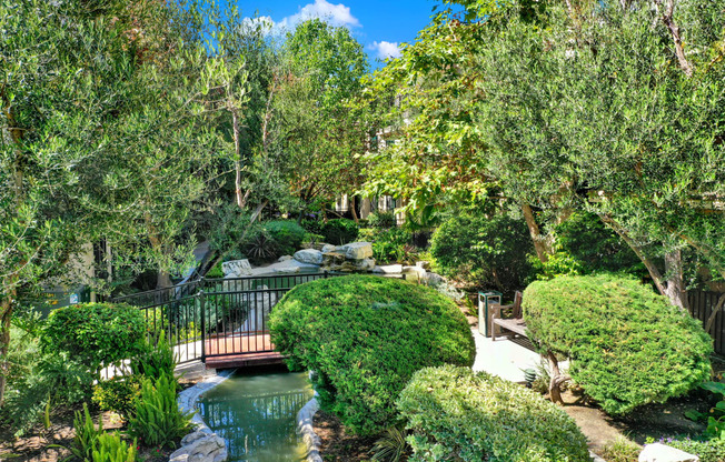 a bridge over a pond in a garden at Willow Tree Apartments, Torrance, CA, 90505