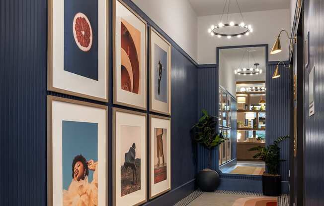 A hallway with a series of framed pictures on the wall.