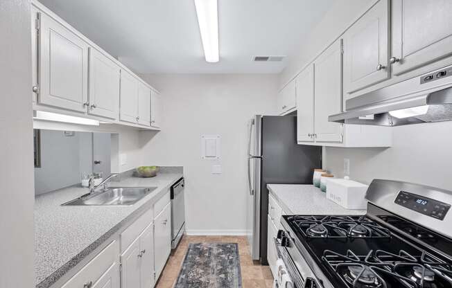 a kitchen with white cabinets and a black stove top oven