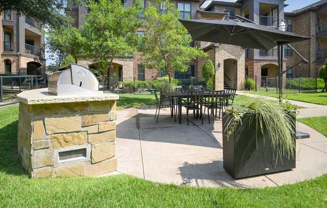 A patio with a fireplace and a table surrounded by chairs.