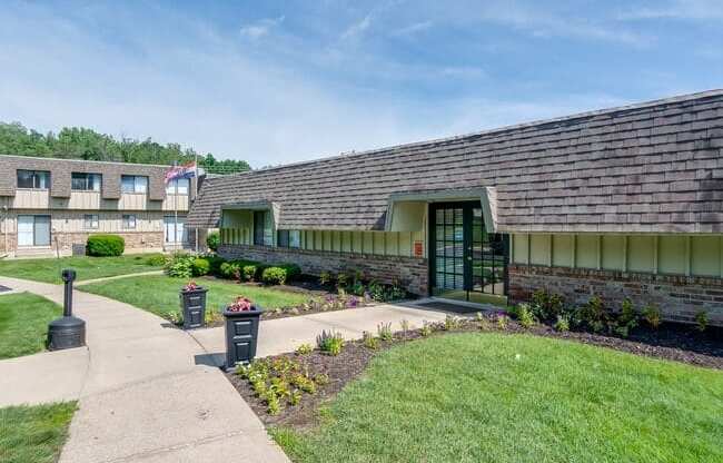 the front of a building with a sidewalk and grass