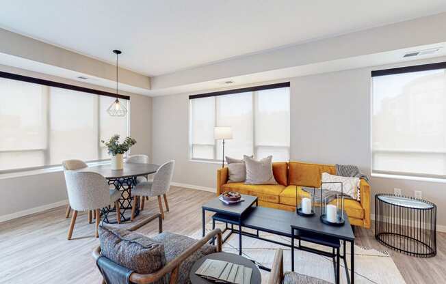a living room with a yellow couch and a dining room table with chairs