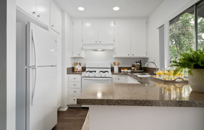 a kitchen with white cabinets and white appliances