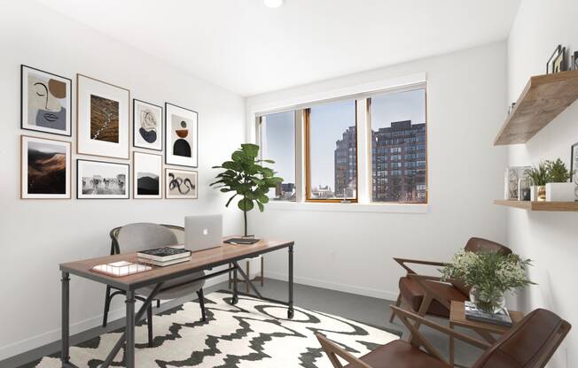 Home office with a desk and a window and a wall of framed photos