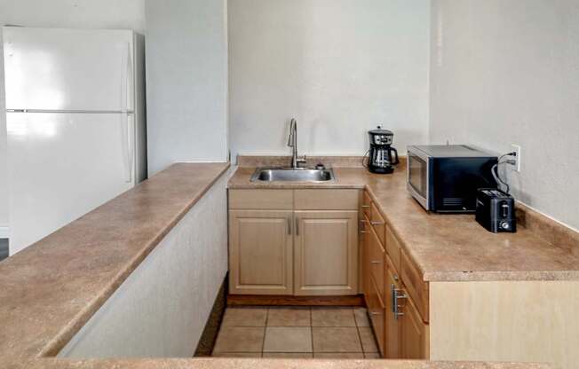 A kitchen with a sink, toaster, and refrigerator.