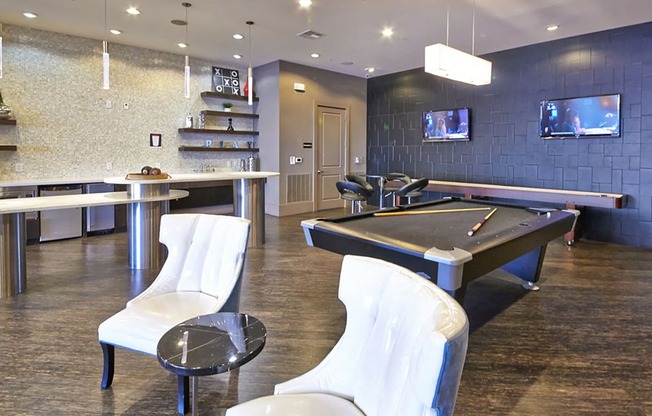 a game room with a pool table and televisions at Mockingbird Flats, Dallas