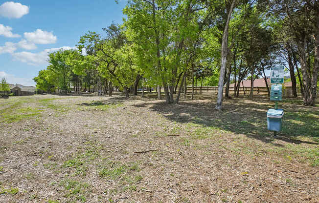 A field with trees and a blue container.