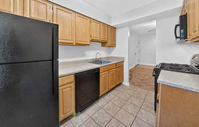 A kitchen with black appliances and wooden cabinets.