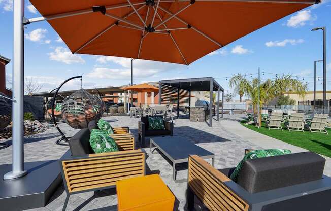 A patio with orange umbrellas and wooden chairs.
