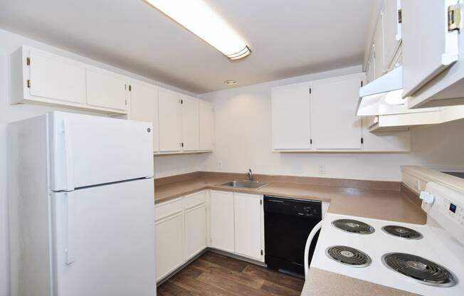 a kitchen with white cabinets and white appliances