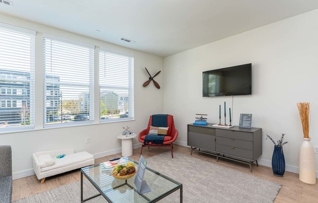 A living room with a red chair and a glass table at the Mastlight.