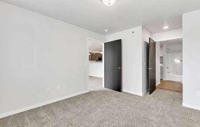 A room with a carpeted floor and a doorway leading to another room.