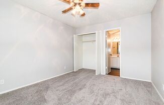 an empty living room with a ceiling fan