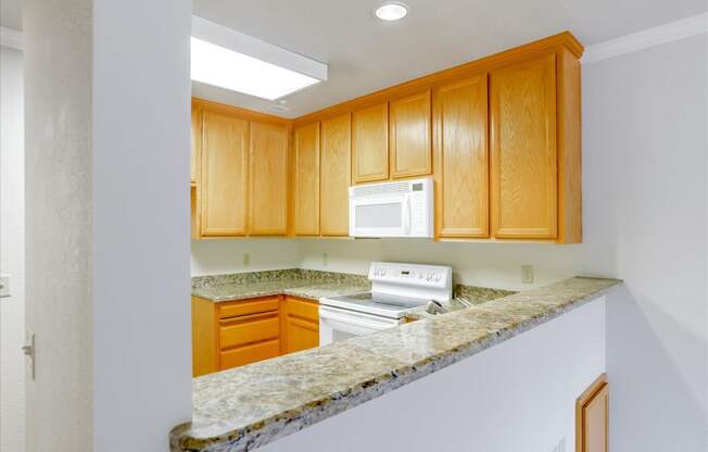 A kitchen with wooden cabinets and a granite countertop.