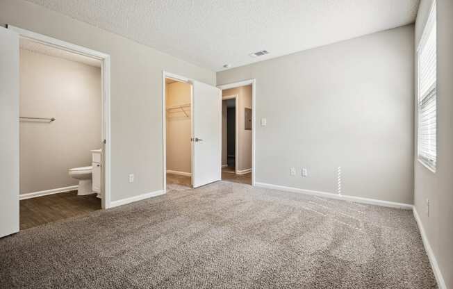 a bedroom with an open door and a bathroom in the background