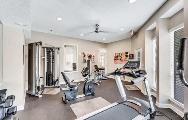 A spacious gym with treadmills, weights, and exercise equipment.