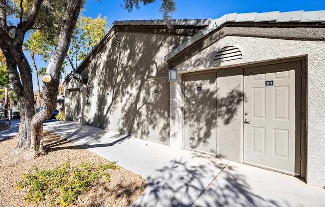 A building with a white door and a tree in front of it.