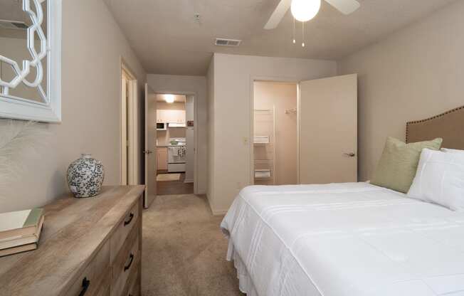 a bedroom with a large white bed and a ceiling fan
