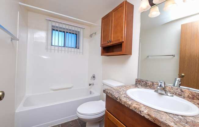 a bathroom with a sink toilet and a bath tub. Fargo, ND North Manor Apartments