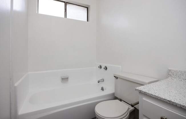 an empty bathroom with a toilet and a bath tub