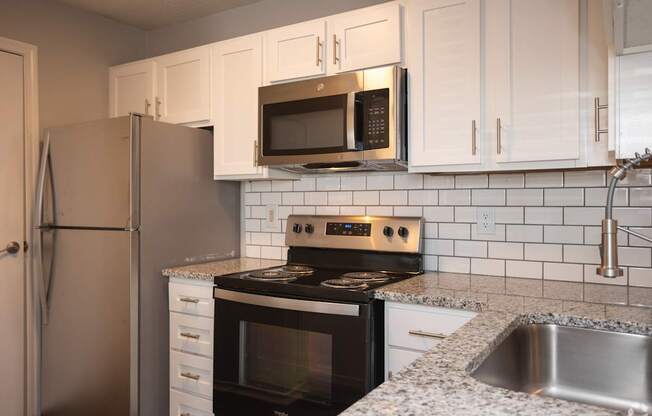 A kitchen with a stove, microwave, and refrigerator.